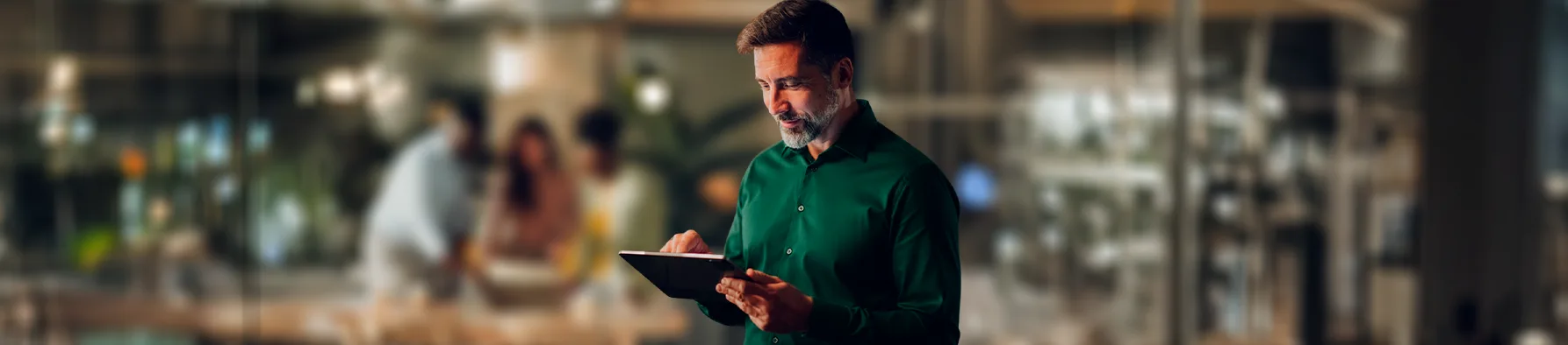 Homem em ambiente corporativo utiliza tablet com foco e agilidade, demonstrando na prática as vantagens da assinatura digital para o negócio.