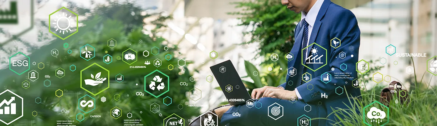 Uma pessoa em traje de negócios está sentada na grama em um ambiente urbano, usando um laptop. Sobre a imagem, há uma sobreposição de ícones digitais de sustentabilidade, como reciclagem e energia limpa. A cena representa a integração da tecnologia e da sustentabilidade, focando em conceitos como a economia circular.