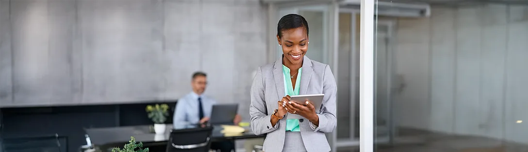 Profissional usando tablet em ambiente de trabalho contemporâneo, exemplificando a aplicação da IA na gestão de contratos para otimizar processos.