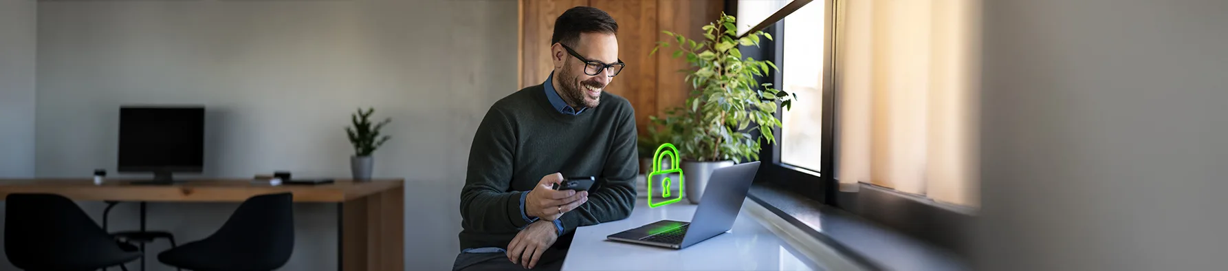 Homem usa notebook e celular ao lado de um cadeado digital verde, ilustrando a Cibersegurança no home office.